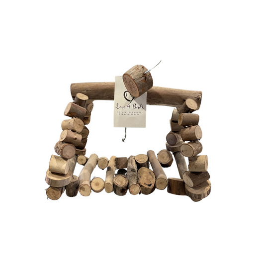 A rustic wooden hut made from natural wood logs and cut stumps, with a small hanging tag reading 'Love & Bark Handcrafted Wood' for birds and small animals