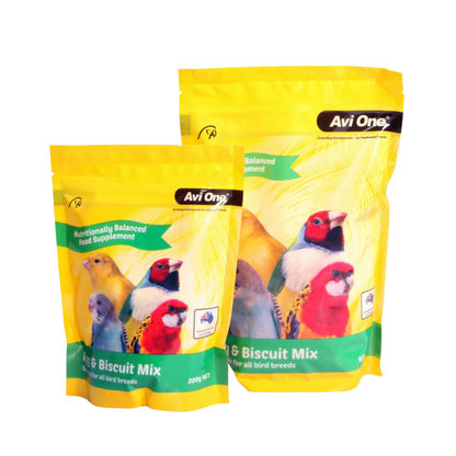 Two yellow Avi One bird biscuit mix pouches on a plain white background, with colorful bird illustrations and the product name 'Bird & Biscuit Mix' visible on the front.